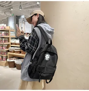 Fashion black casual backpack for students, featuring a cute bear patch and durable design.