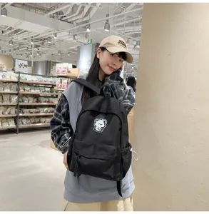 Minimalist black school backpack for teenage girls with cute bear patch, daily casual student bag.