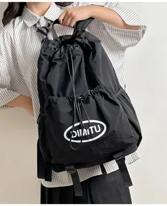 Detail view of the black drawstring backpack showing printed logo and durable outdoor fabric.