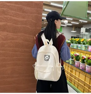 Minimalist canvas student backpack with cute bear patch, stylish daily school bag for girls.