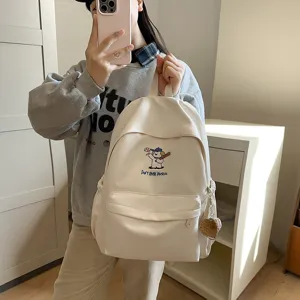 Stylish canvas school backpack for teen girls with cute cartoon graphic and large capacity.