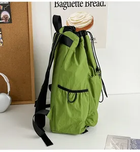 Detailed view of the green outdoor drawstring backpack, lightweight nylon material, side pockets.