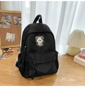 Stylish black student backpack with cute bear patch, casual minimalist school rucksack daily.