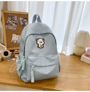 Casual light blue school backpack for teen girls with cute bear patch and chic style daily use.