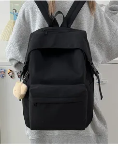 Black nylon backpack detail, lightweight daily school bag with front pocket and charm.