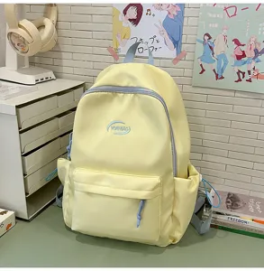 Vista detallada de una linda mochila escolar amarilla con cremalleras azul claro.