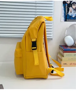 Yellow nylon backpack side detail showing durable buckles, straps, and minimalist design.