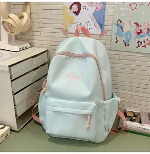 Linda mochila escolar azul pastel para adolescentes con correas rosadas y varios bolsillos.