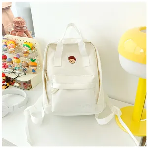 White canvas mini backpack for women, casual school bookbag with cute bear embroidery.