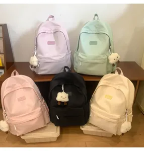 Detail view of canvas school backpack with cute cloud charm and front pocket storage.