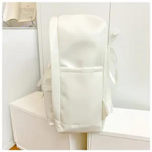 Detailed view of white minimalist casual backpack with front pocket and side handle.