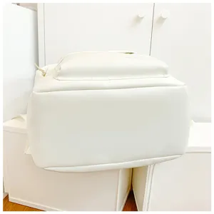 Detail shot of white minimalist canvas school backpack with front pocket and clean design.
