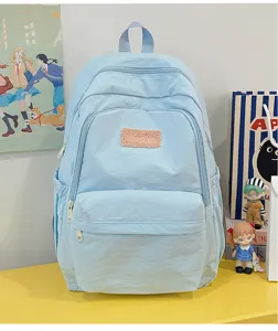 Light blue casual backpack with fuzzy patch, multiple pockets and smooth zippers for daily use.