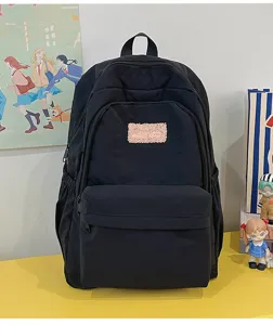 Black casual school backpack detail showcasing front fuzzy patch and multi-pocket design.
