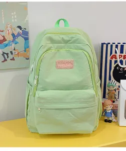 Light green casual school backpack detail view with multiple compartments and a cute fuzzy patch.