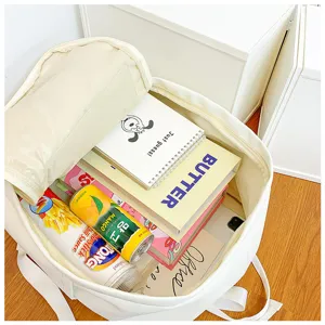 Close-up detail showing the spacious interior compartment of a casual white canvas backpack.