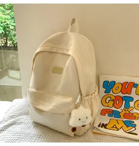 Minimalist solid color canvas school backpack with cute cloud pendant for daily use.