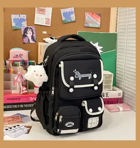 Detail view of Japanese college style black canvas backpack with multi pockets and cute plush charm.