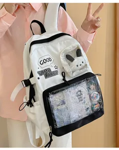 Primer plano de una bonita mochila ita en blanco y negro con ventana transparente y peluche.