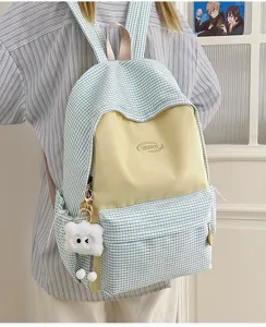 Detail shot of a stylish Japanese grid backpack in blue and yellow with cute plush pendant.