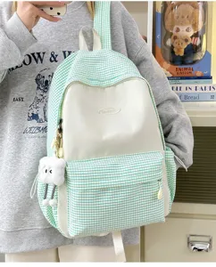 Detail shot of the Japanese style plaid backpack in light green and white with front storage pocket.