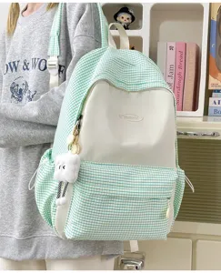 Detailed view of green plaid backpack with cute plush pendant, large capacity school bag design.
