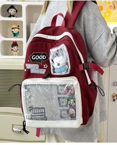 Mochila Ita burdeos con ventana transparente, chapas de anime y colgante de peluche.