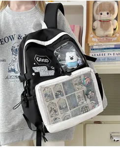 Mochila ita negra y blanca con bolsillo frontal transparente para pines y adorables peluches.