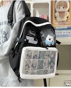 Mochila ita negra y blanca con bolsillo delantero transparente para chapas de anime y peluche.