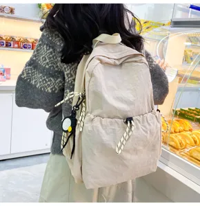 Detail view of light beige nylon backpack, casual large capacity school bag for daily travel.