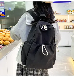 Close-up of black nylon backpack with white drawstring, practical daily casual school bag.