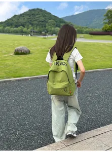 Detail view of the casual green canvas backpack worn outdoors, featuring Korean style.