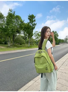 Detailed close-up view of the casual green Korean style canvas backpack worn outdoors.