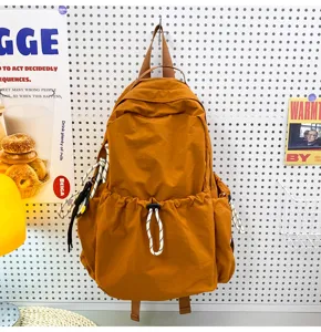 Detailed view of solid color nylon backpack hanging on pegboard wall, casual style design.