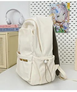 Detail view of minimalist beige canvas casual backpack with side pocket and front zipper.