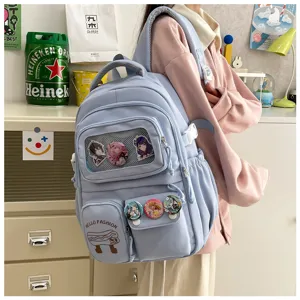 Detailed view of cute light blue student backpack featuring clear window pocket and anime badges.