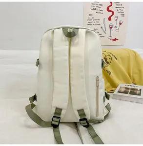 Close-up detail of the casual white backpack featuring sturdy green straps and pocket.