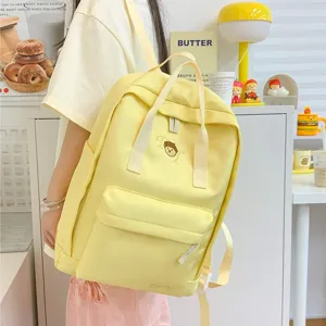 Korean style canvas backpack for women, cute yellow school bag with double handles and front pocket.