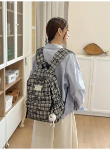 Detailed view showcasing a Japanese style plaid backpack featuring cute plush pendant and straps.