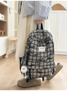 Detailed view of Japanese style plaid school backpack with cute plush pendant for daily use.