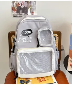 Mochila escolar casual gris de lona con ventana transparente para pines y uso diario.