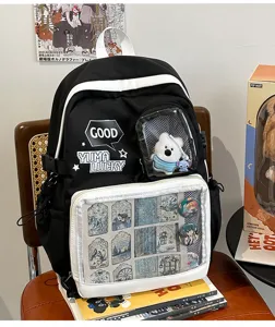 Mochila itabag en blanco y negro con bolsillo frontal transparente para pines, grande.