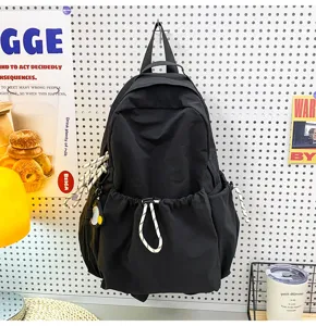 Black nylon backpack detail view, featuring large capacity and convenient drawstrings.