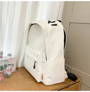 Casual minimalist white canvas backpack with front pocket and side storage for daily use.