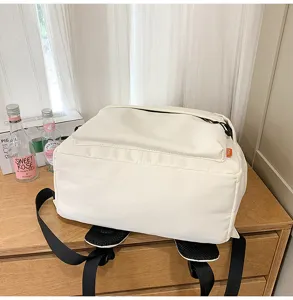 Minimalist white casual backpack with front pocket and black straps, perfect daily school bag.
