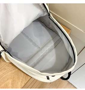 Detailed view of the spacious white backpack interior with grey lining and multiple compartments.