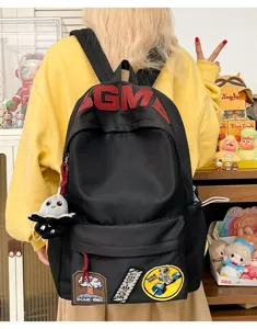 Details of the trendy black canvas backpack with stylish patches, large capacity for daily use.