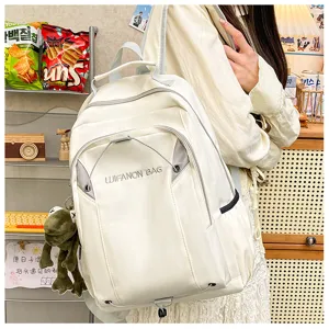 Detail shot of white waterproof backpack worn by model, showing capacity and style.