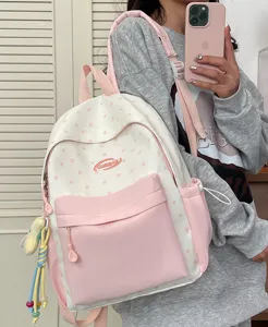 Pink and white star pattern school backpack detail, showing the front pocket and side design.