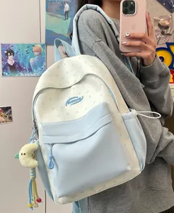 Detail view of the fresh blue and white star backpack, featuring front pocket and moon charm.